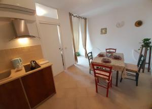 アルベロベッロにあるNonna Livia - vicino centro storico Trulliのテーブルと椅子のあるキッチンとダイニングルーム