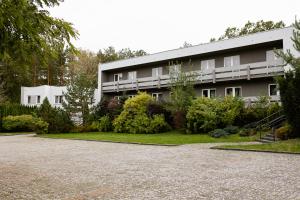 a building with a lot of bushes in front of it at Ośrodek Wypoczynkowo-Rehabilitacyjny Perła Borów in Tleń