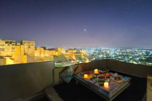 a table with candles on a balcony with a view at Hotel Rajmandir in Jaisalmer