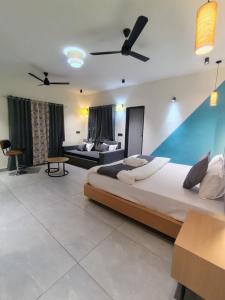 a large bedroom with a large bed and a couch at Peach stay in Mount Ābu