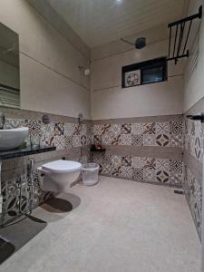 a bathroom with a toilet and a sink at Peach stay in Mount Ābu +19 photos