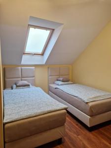 two beds in a bedroom with a skylight at Prywatny Dom z Parkingiem Trzy Sypialnie Self check-in Faktura in Rzeszów