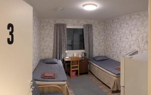 a small bedroom with two beds and a desk at Pink Nissi in Kuusamo