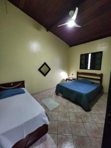 a bedroom with two beds and a ceiling fan at Refúgio com Piscina, Churrasco e Lazer no Campo in Sumaré +23 photos