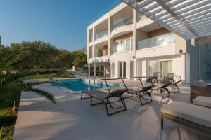 Un patio con sillas y una piscina y un edificio. en Apartments with swimming pool Promajna, Makarska - 19144, en Promajna