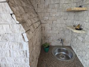 a bathroom with a sink in a stone wall at TerraLuxe Sarajevo in Sarajevo +19 photos