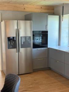 una cucina con frigorifero in acciaio inox di Hyggehouse-Unser-Ferienhaus-an-der-deutsch-daenischen-Grenze a Rudbøl