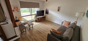 a living room with a couch and a television at Beach side studio Quindalup in Quindalup