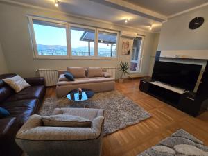 a living room with a couch and a television at TerraLuxe Sarajevo in Sarajevo