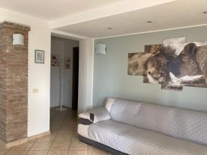 ein Wohnzimmer mit einer Couch und Gemälden an der Wand in der Unterkunft Milele B&B in Somma Lombardo