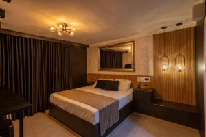 a hotel room with a bed and a mirror at Hotel Motel Paradiso - Carazinho-RS in Caràzinho