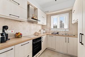 a kitchen with white cabinets and a black dishwasher at Apartment Ino in Protaras