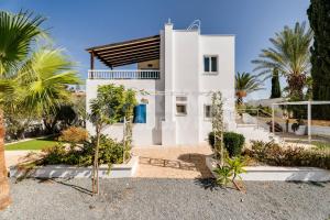 a white house with palm trees in front of it at Apartment Ino in Protaras