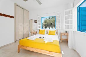 a bedroom with a bed with yellow pillows and a window at Apartment Themis in Protaras