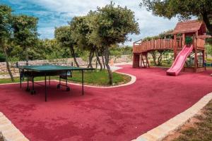 a playground with a table and a slide at Family-friendly apartments with swimming pool Mandre, Pag - 24196 in Kolan
