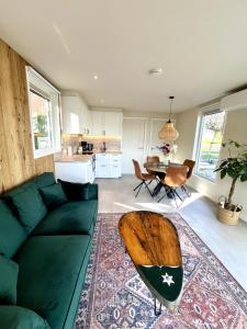 a living room with a green couch and a table at Houseboat Sneek in Sneek