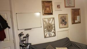 埃尔特姆Guest house in rear garden的一间有白色板和墙上时钟的房间