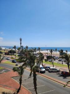 a view of a street with palm trees and the beach at 27 on North Beach in Durban +20 photos