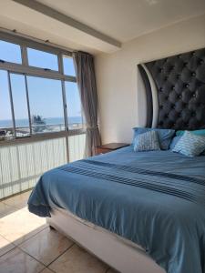 a bedroom with a large bed with a large window at 27 on North Beach in Durban