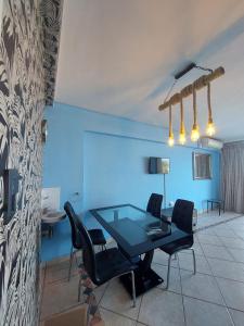 a dining room with a glass table and black chairs at 27 on North Beach in Durban