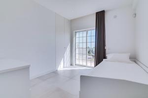 an empty white room with a bed and a window at Casa Nuria com 4 quartos, piscina e churrasco em Vale do Lobo in Almancil +26 photos