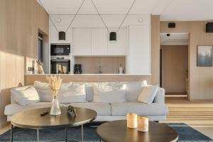 a living room with a white couch and two tables at Serene cabin in Lofoten with sauna in Storøya