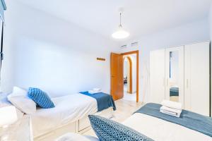 ein Zimmer mit zwei Betten und einem Stuhl in der Unterkunft VB Albatros - 2BR Apartment Close to the sea in Benalmádena + 14 Fotos