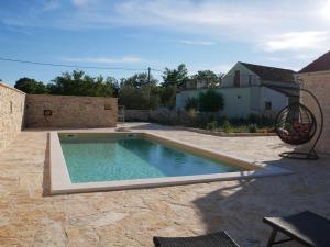 a swimming pool in the yard of a house at Villa Didova kuca ZadarVillas in Podlug