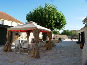 a table and chairs under an umbrella on a patio at Villa Didova kuca ZadarVillas in Podlug