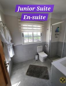 ein Badezimmer mit Toilette und einem EM-Suite-Schild in der Unterkunft Casa Mariposa in Playa de San Juan