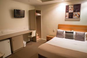 a hotel room with a bed and a television at Burkes Hotel Motel in Yarrawonga
