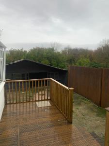 a wooden deck with a fence in front of a house at Cosy Home Cardiff in Cardiff