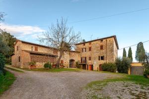 a large stone building with a road in front of it at Il Tinaio di Mary in Cetona