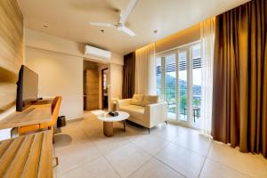 a living room with a couch and a chair and a television at MYSA Sky Suites, Lakkidi in Vythiri