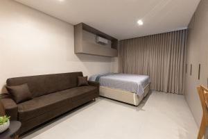 a small room with a couch and a bed at Estúdios modernos no Empiria by WeHousy in Luis Eduardo Magalhaes +31 photos