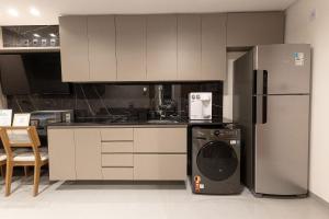 a kitchen with a refrigerator and a washing machine at Estúdios modernos no Empiria by WeHousy in Luis Eduardo Magalhaes