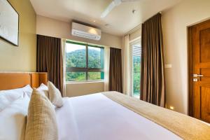 a bedroom with a bed and a window at MYSA Sky Suites, Lakkidi in Vythiri