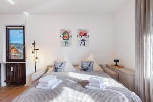 Ferienwohnung Niki في Titisee: غرفة نوم بيضاء مع سرير مع وسادتين