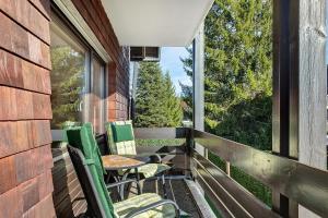 Ferienwohnung Niki في Titisee: بلكونه فيها كراسي وطاولة ونافذة