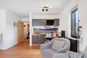 Ferienwohnung Niki في Titisee: غرفة معيشة مع أريكة ومطبخ