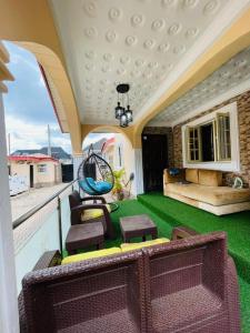 イバダンにあるCozy 4-Bedroom Home in Ibadanの緑の芝生とバルコニーに椅子が置かれたポーチ +15枚の写真