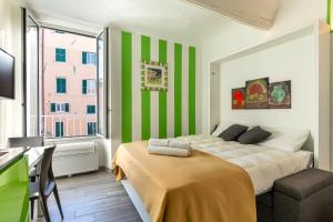 een slaapkamer met een bed, een bureau en een raam bij La Casetta Verde con Vista Mare - Nel cuore del Parasio e delle Logge di Santa Chiara in Imperia +19 foto's