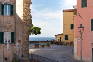een steegje tussen twee gebouwen met de oceaan op de achtergrond bij La Casetta Verde con Vista Mare - Nel cuore del Parasio e delle Logge di Santa Chiara in Imperia