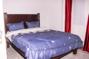 a bed with a blue comforter and blue pillows at Narok Comfy Homes in Narok