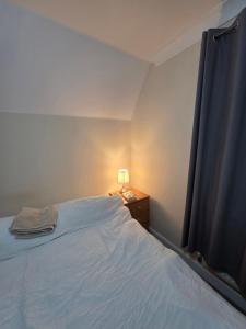 a bedroom with a bed and a lamp on a night stand at Cozy Guest Room in Colchester - Perfect for Travelers in Hythe