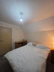 a bedroom with a white bed and a desk at Cozy Guest Room in Colchester - Perfect for Travelers in Hythe