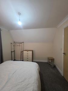 a bedroom with a bed and a dresser in it at Cozy Guest Room in Colchester - Perfect for Travelers in Hythe