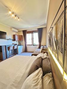 a bedroom with a large bed and a kitchen at Apartment Centar in Podgorica