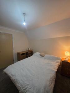 a bedroom with a large white bed and a desk at Cozy Guest Room in Colchester - Perfect for Travelers in Hythe +4 photos