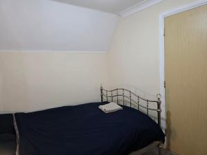 a bedroom with a bed with a blue blanket at Guest Room in Colchester Hythe in Hythe +2 photos
